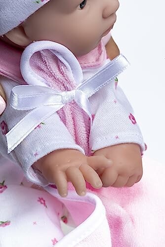 Hand van babypop in roze kleding