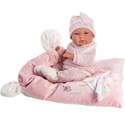 Baby pop op roze kussen met muts en speen