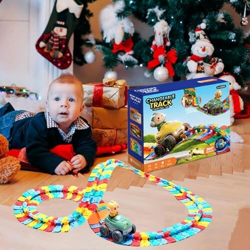 Baby speelt met speelgoedracebaan voor kerstboom