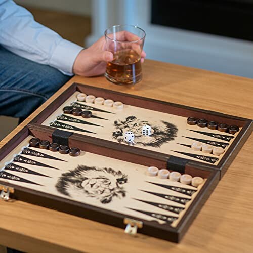 Backgammonspel op tafel met glas drinken