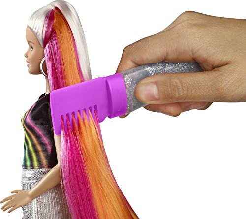 Barbiepop met kleurrijk haar wordt gekamd