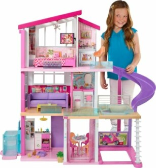 Meisje naast Barbie-poppenhuis met glijbaan