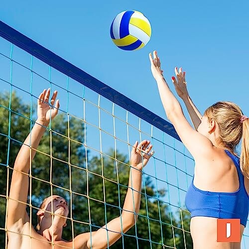 Twee mensen spelen beachvolleybal bij het net.