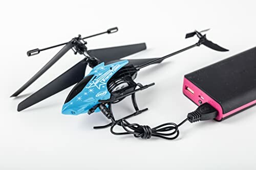 Blauwe helikopter die wordt opgeladen met powerbank.