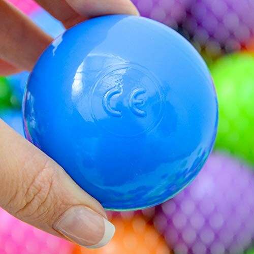 Blauwe stressbal in hand met gekleurde achtergrond.