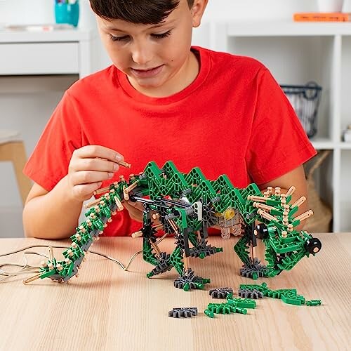 Kind bouwt groene robotdinosaurus met speelgoed