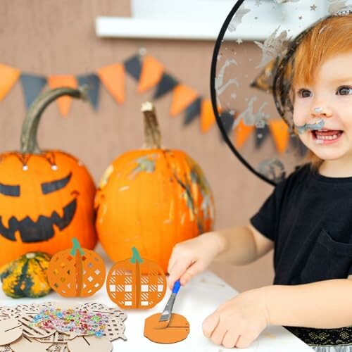 Kind maakt Halloween knutselwerk met pompoenen