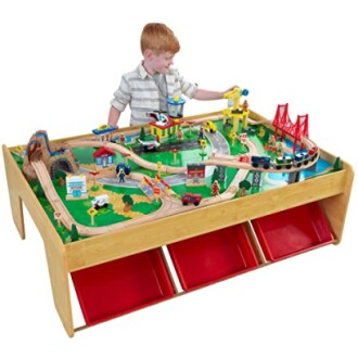 Kind speelt met een houten treintafel.