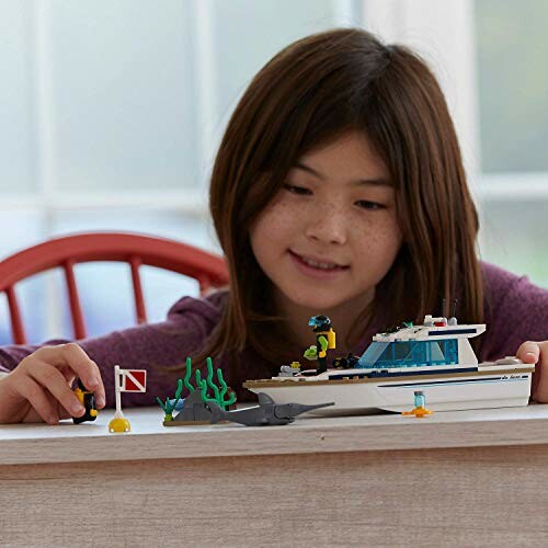 Kind speelt met LEGO-boot op tafel