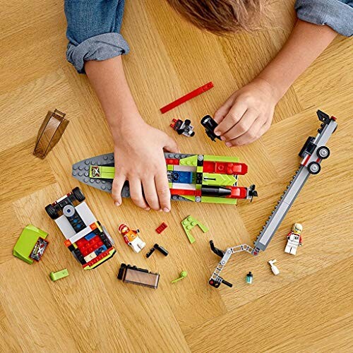 Kind speelt met Lego-set op houten vloer.