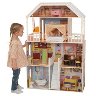 Kind speelt met poppenhuis met meerdere kamers.