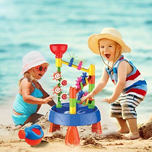 Kinderen spelen op het strand met een speelgoedwatertafel.