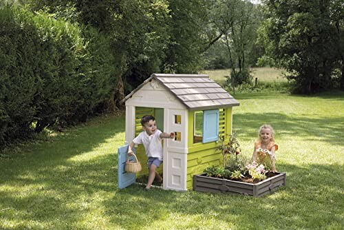 Kinderen spelen in een tuin met een speelhuisje.