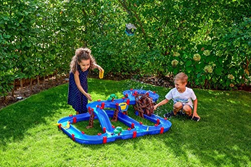 Twee kinderen spelen met een watertafel in de tuin.