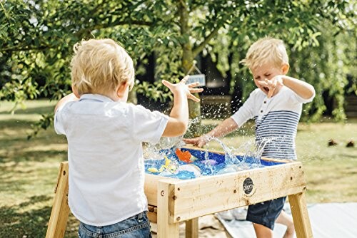 Kinderen spelen met watertafel in de tuin.