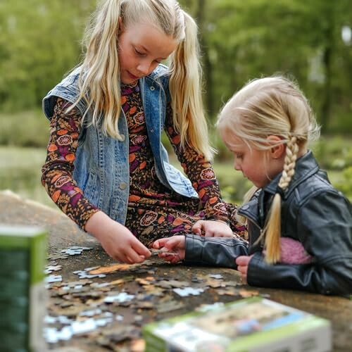 Twee meisjes maken een puzzel in de buitenlucht.