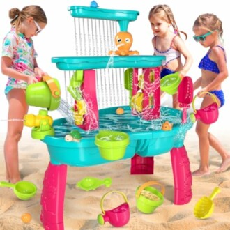 Kinderen spelen met een watertafel op het strand.