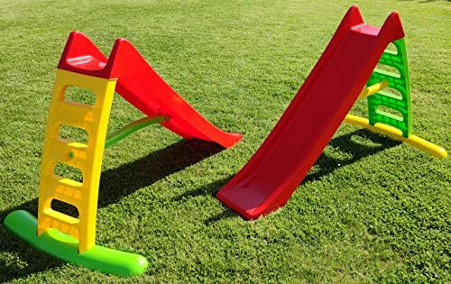 Twee kleurrijke glijbanen op grasveld