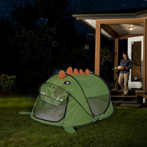 Groene dinosaurus tent in de tuin bij nacht