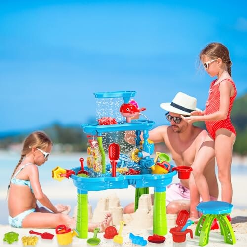 Kinderen spelen met zand en speelgoed op het strand met hun vader.