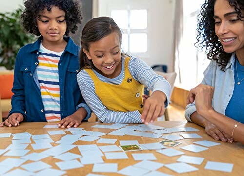 Kinderen spelen geheugenspel aan tafel met volwassene.