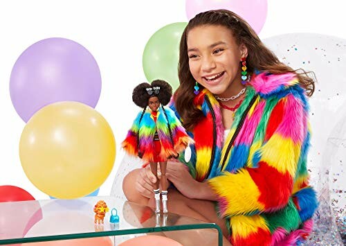 Meisje speelt met pop in regenboog bontjas en ballonnen