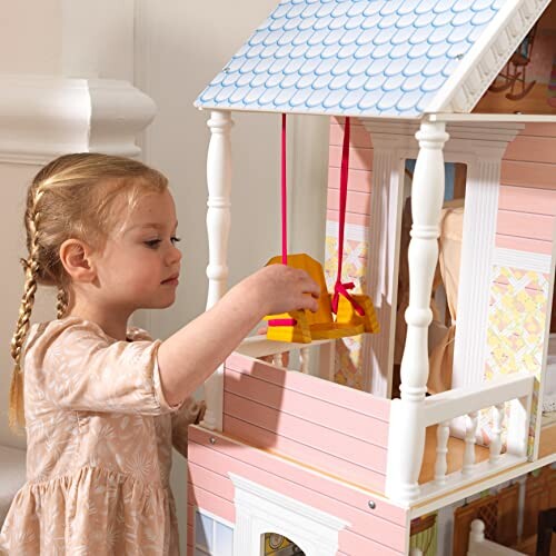 Meisje speelt met poppenhuis