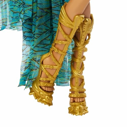 Poppenbenen met gouden gladiator-sandalen en blauwe jurk