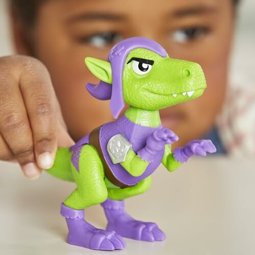 Groene dinosaurus speelgoedfiguur met paarse accessoires.