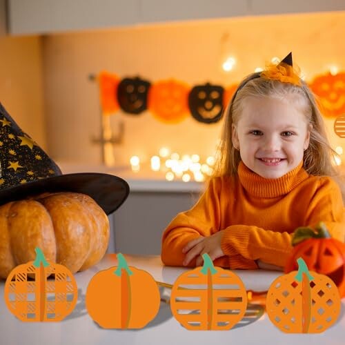 Meisje in oranje trui met Halloween-pompoenen en decoratie