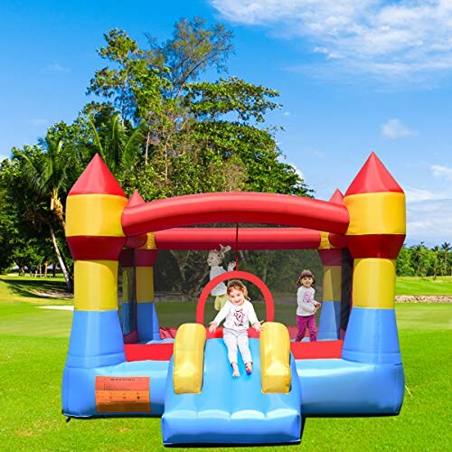 Kinderen spelen in een kleurrijk springkasteel op gras.