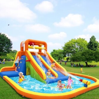 Kinderen spelen op een opblaasbare waterglijbaan in het park.