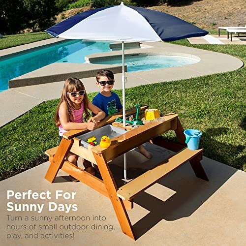 Kinderen spelen aan een picknicktafel met parasol bij het zwembad.