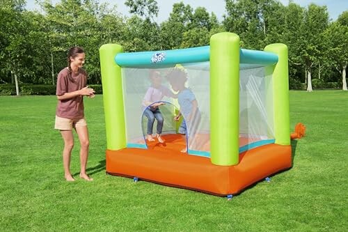 Kinderen spelen in een springkasteel op het gras