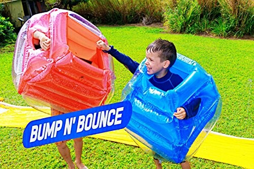 Kinderen spelen met opblaasbare stootkussens in de tuin.