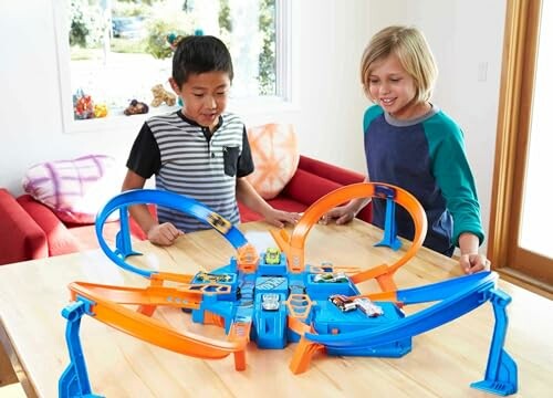 Kinderen spelen met speelgoedracebaan op tafel.