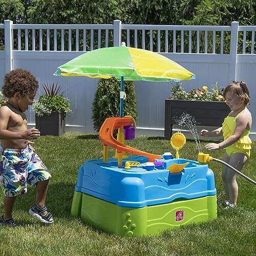 Kinderen spelen met watertafel in tuin.