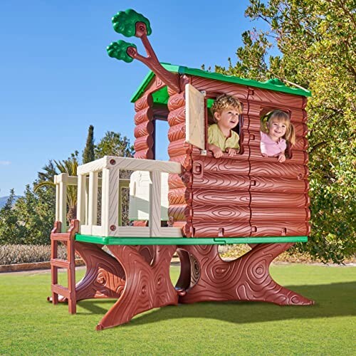 Kinderen in een houten boomhut op een grasveld.