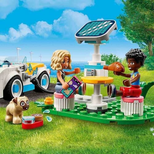 Kinderen spelen met LEGO-set in park met speelgoedauto en zonnepanelen.