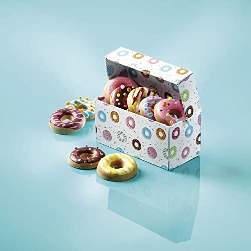 Mini donuts in kleurrijke doos met enkele donuts buiten de doos.