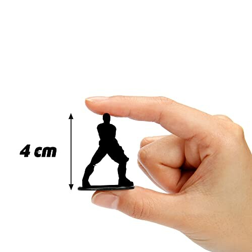 Miniatuur figuur tussen vingers van een hand.