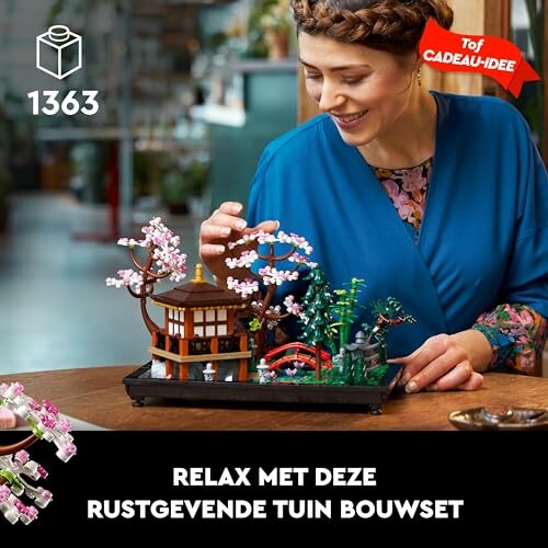 Vrouw bouwt miniatuurtuin met bloeiende bomen.