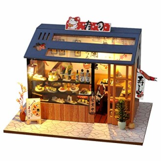 Miniatuur sushi winkel diorama met verlichte ramen en decoraties.