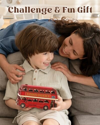 Moeder en kind spelen met een rood Londens speelgoedbusje.