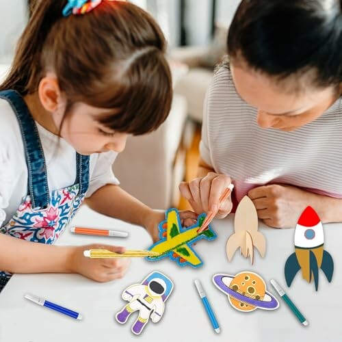 Moeder en dochter maken ruimtevaartknutsels aan tafel.