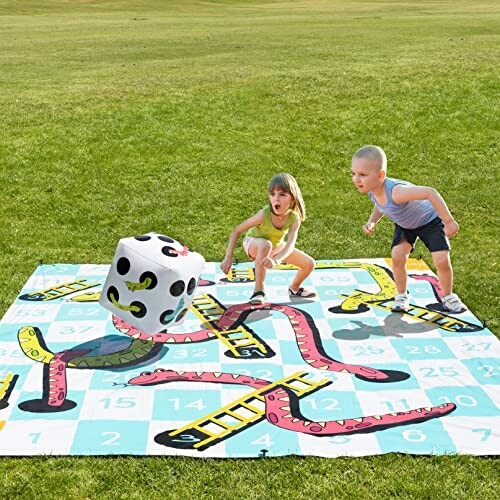 Kinderen spelen een groot slangen en ladders spel op grasveld.