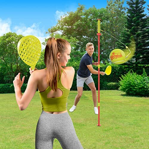 Twee mensen spelen een swingballspel in de tuin.