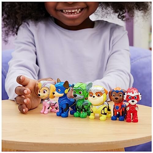 Kind speelt met Paw Patrol speelgoedfiguren op tafel.