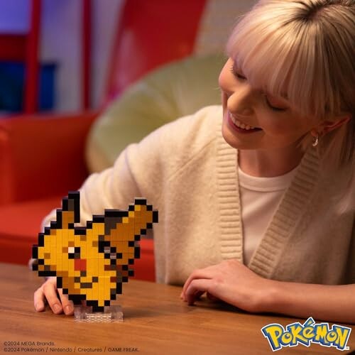 Vrouw toont pixelachtige Pikachu-figuur