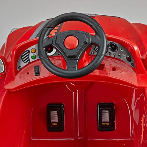 Dashboard van een rood speelgoedauto met stuur